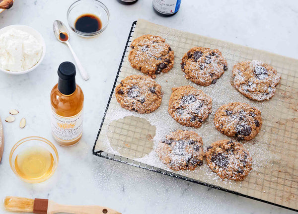 Picture of nine fresh flourless almond butter cookies next to simple syrup and vanilla extract