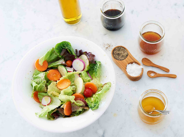 Picture of fresh salad with four salad dressings infused with simple syrups
