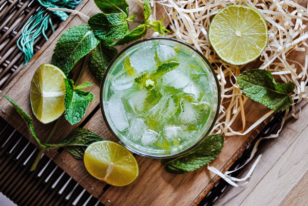 Mojito Spritzer in a glass with fresh mint leaves and lime wedges