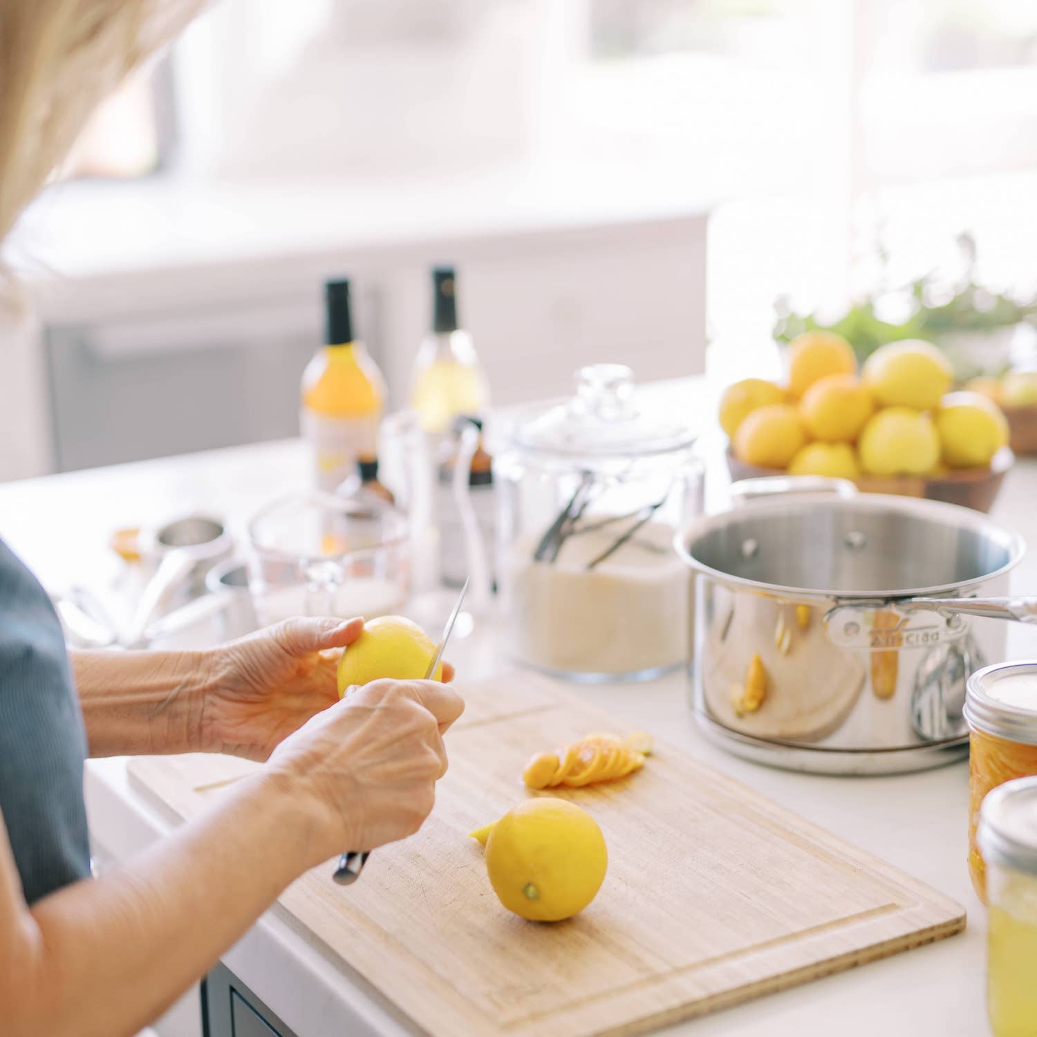 Chef slicing lemons in kitchen with simple syrups for candied meyer lemons recipe